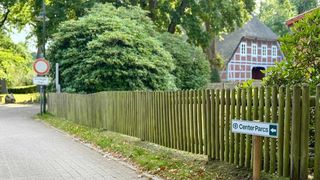 Ein ruhiger Weg durch grüne Natur führt zu einem traditionellen Fachwerkhaus in Bispingen.