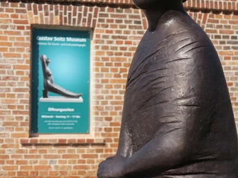 Sappho mit Plakat vor dem Gustav Seitz Museum