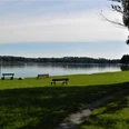 Gedenkstele, Ligewiese und Sitzbänke mit dem Blick auf den Schwielochsee