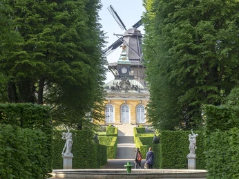 Parkblick zu den Neuen Kammern von Sanssouci mit Historischer Mühle dahinter