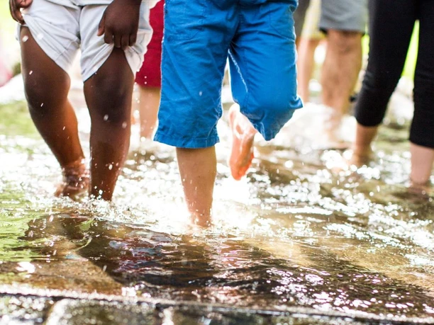 Barfußpark - Kinderfüße laufen durch Wasser