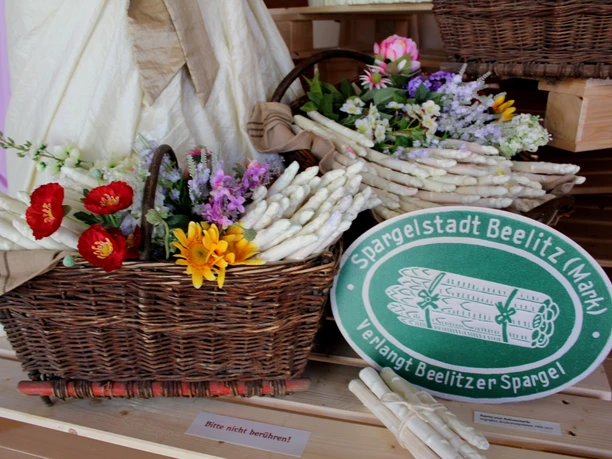 Körbe mit Spargel und Feldblumen