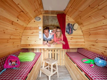 Familie in dem Schlaffass auf dem Naturcampingplatz am Springsee