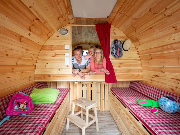 Familie in dem Schlaffass auf dem Naturcampingplatz am Springsee