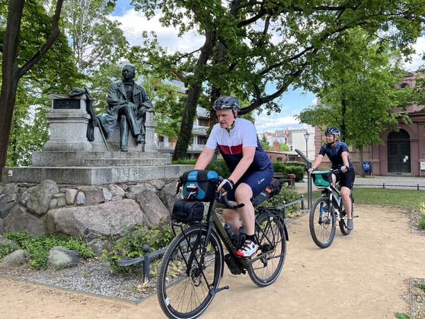 Radler vorm Fontane-Denkmal in Neuruppin
