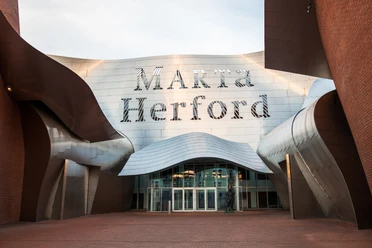 Moderne Architektur des Marta Herford Museums mit geschwungenen Metallfassaden und Glasfront.