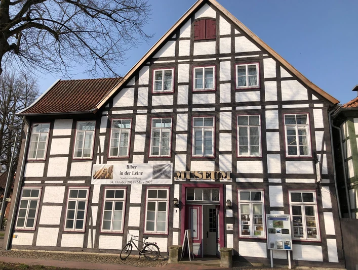 Museum zur Stadtgeschichte Fachwerkgebäude mit weißer Fassade und braunen Holzbalken, Eingangstür mit Museumsaufschrift.