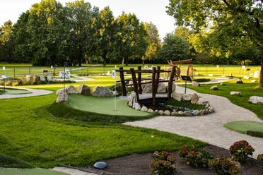 Minigolfanlage-pietzmoor-foto_ccbysa_foto©adventure-schnucken-golf-min.jpg Die Minigolfanlage in Pietzmoor zeigt grüne Bahnen, umgeben von Kieswegen und Bäumen.