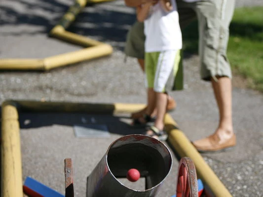 Vater mit Sohn beim Minigolf