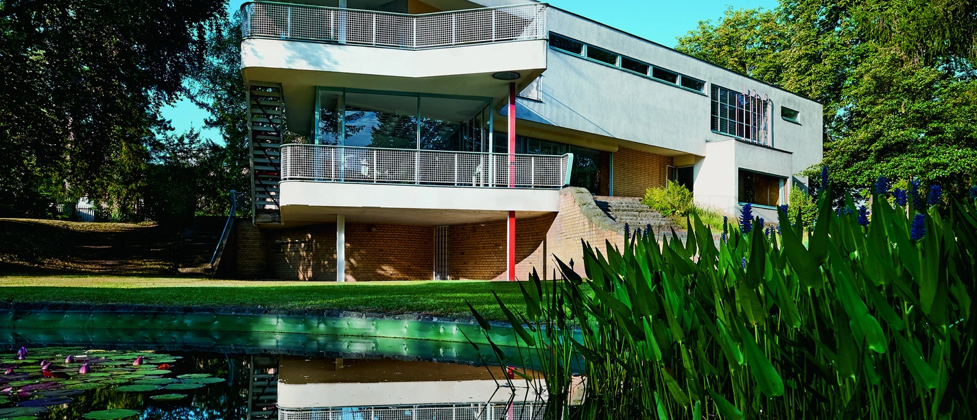 01_HausSchminke_Gartenansicht_vonNO_MSchroeder.jpg Moderne Architektur des Hauses Schminke mit Teich im Vordergrund.