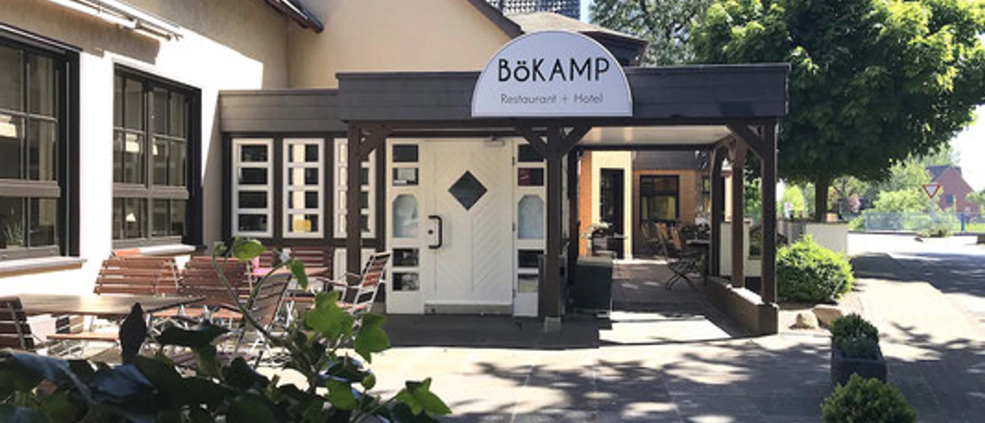 Gemütlicher Eingangsbereich des Bökamp Restaurants und Hotels mit Sitzgelegenheiten im Freien.