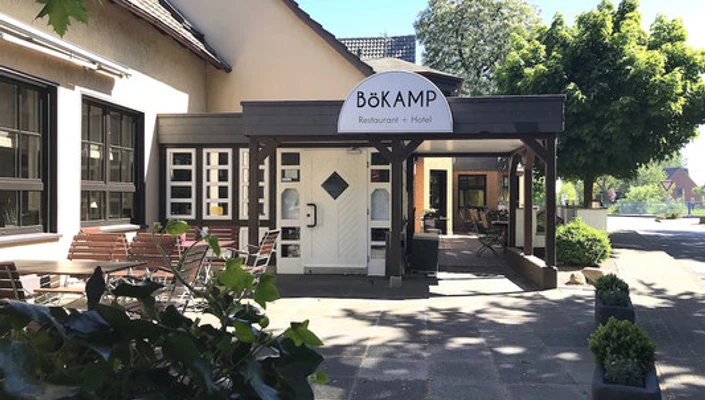 Gasthof Bökamp_Außenansicht2 Gemütlicher Eingangsbereich des Bökamp Restaurants und Hotels mit Sitzgelegenheiten im Freien.