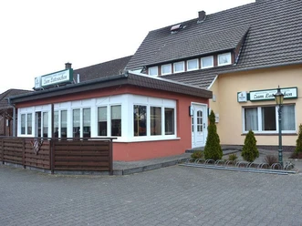 Eingangsbereich eines traditionsreichen Gasthofs mit Außenfassade in warmen Farben und stilvollen Fenstern.