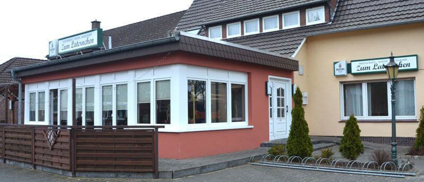 Eingangsbereich eines traditionsreichen Gasthofs mit Außenfassade in warmen Farben und stilvollen Fenstern.