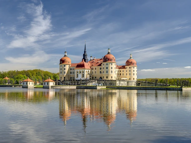 MOR_Carlo_Boettger_SM_5_2.362x1.181px_2014.jpg Schloss Moritzburg spiegelt sich majestätisch in einem See, umgeben von grünen Wäldern.