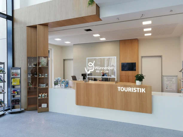 Touristinfo im KuGA Touristinformation im modernen Büro mit Holztheke und Regalen, Prospekten und hellem Interieur.