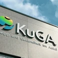 KuGA Fassade des Gesundheitszentrums KuGA mit modernem Logo und Schriftzug unter blauem Himmel.