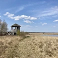 Oppenweher Moor Aussichtsturm aus Holz am Oppenweher Moor, umgeben von Heidelandschaft und Wolken am blauen Himmel.