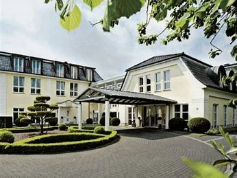 Hotel Sonne Helles, modernes Hotel mit einladender Auffahrt, charakteristischer Landschaftsgärtnerei und Bäumen.