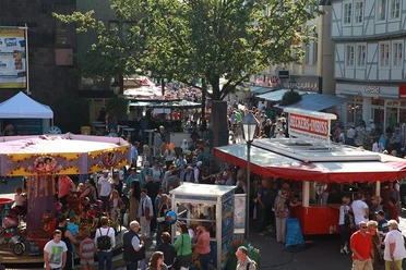 Blick von oben in die Menge mit einem Kinderkarussell und Imbisswagen