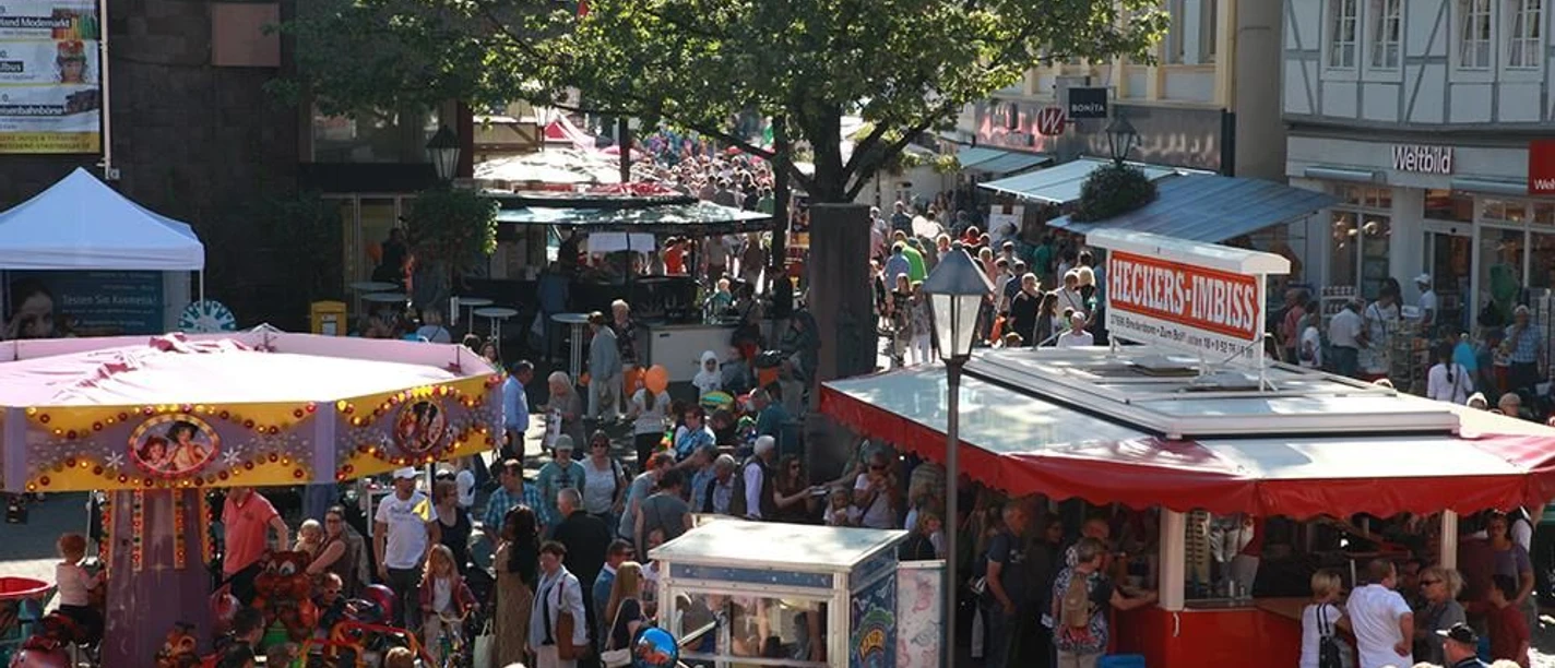 Huxori.jpg Blick von oben in die Menge mit einem Kinderkarussell und Imbisswagen