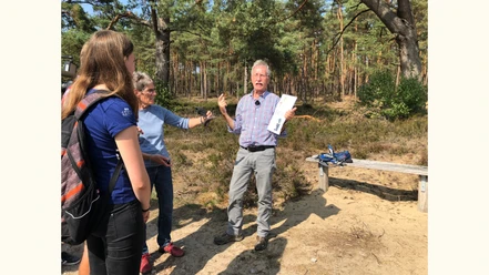 Wolfgang Koltermann Wolfgang Koltermann spricht leidenschaftlich in einem sonnigen Kiefernwald zu Zuhörern.