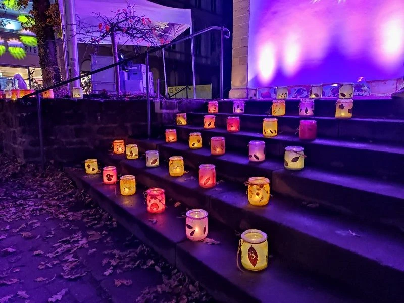 Lichterglanz.jpg Laternen aus buntem Glas erhellen eine steinerne Treppe in farbenfrohen Lichtschattierungen bei Nacht.