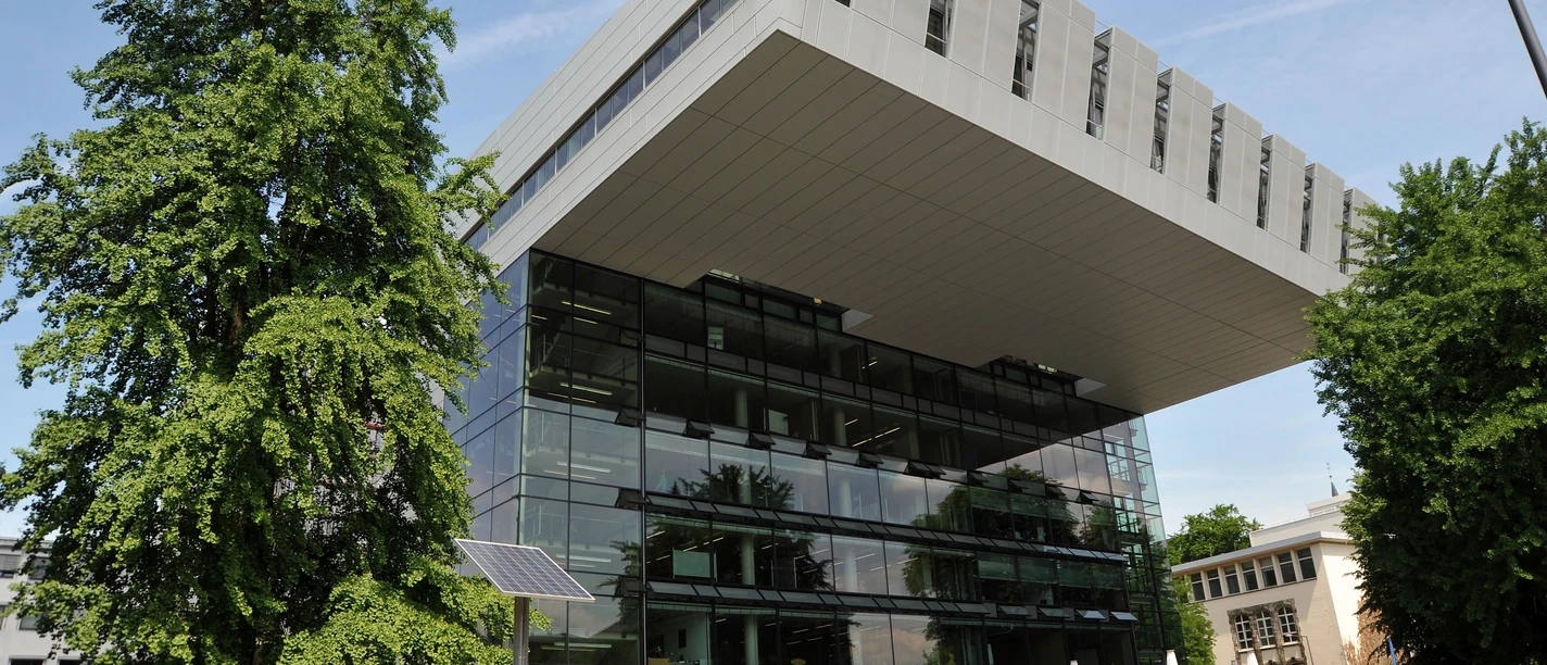 RWTH University Aachen SuperC Außenansicht des Super C Gebäudes der RWTH Aachen mit markant auskragendem Dach, Glasfassade und Vorplatz mit Passanten.
