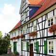 Biohof Judt im Windrather Tal bei Velbert Fachwerkhaus im Windrather Tal bei Velbert mit roten Dächern und grünen Fensterläden im ruhigen Umfeld.