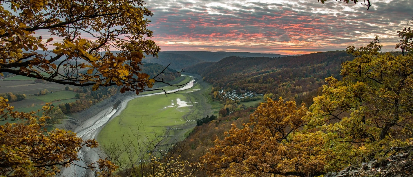 Herbstlicher Sonnenuntergang von einem knorrigen Eichenhang