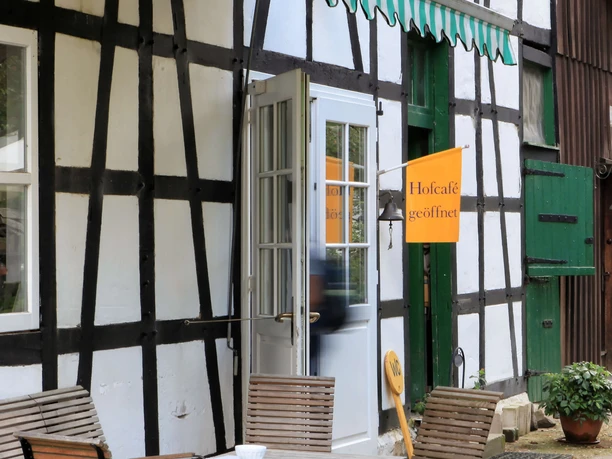 Biohof Hofcafe auf Hof zur Hellen im Windrather Tal be Velbert Traditionelles Fachwerkhaus mit Außenterrasse und geöffnetem Hofcafé im Windrather Tal bei Velbert.