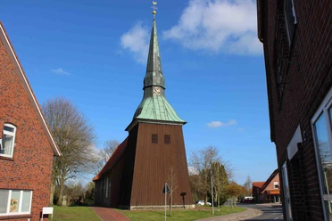 Historische St. Petri Kirche in Osterbruch mit imposantem Holzturm und grünem Kupferdach.