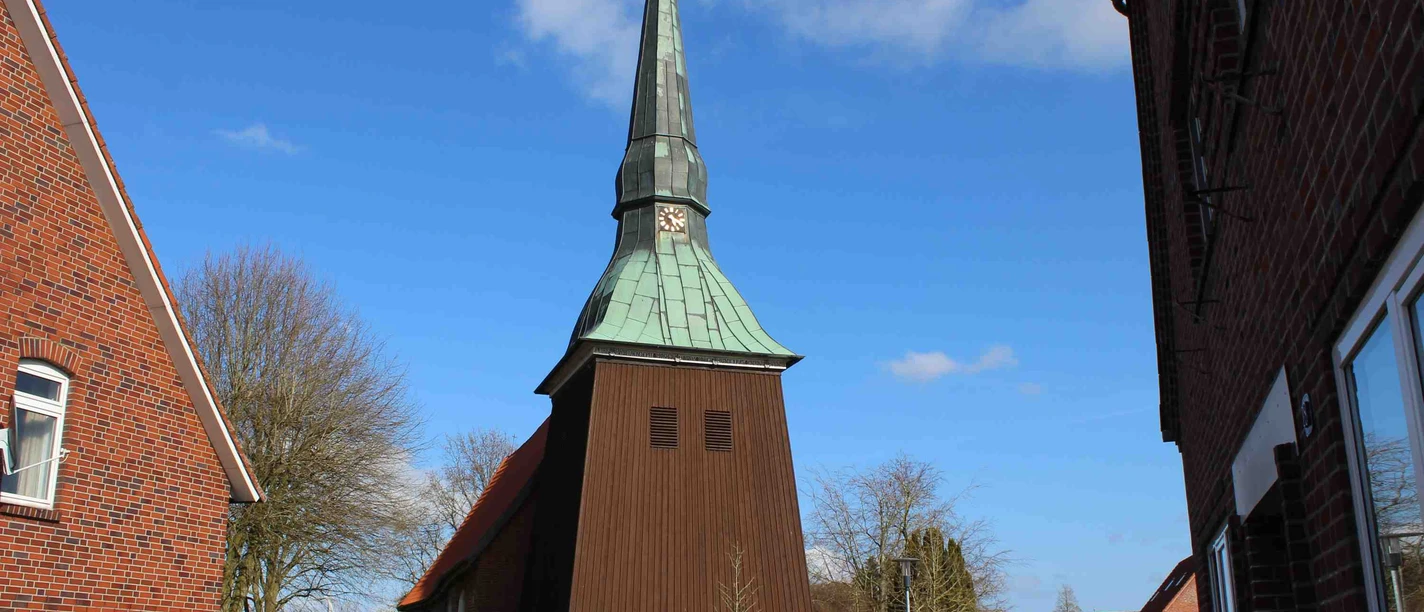 Historische St. Petri Kirche in Osterbruch mit imposantem Holzturm und grünem Kupferdach.