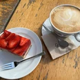 Kaffee und Kuchen Kaffeetasse mit Latte Art und Erdbeerkuchenstück auf Holztisch, bereit zum Genuss.