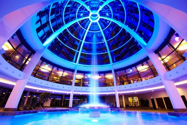 Kuppel der carpesol SPA Therme in Bad Rothenfelde Dome-lit bathing paradise with blue light and a central water fountain.