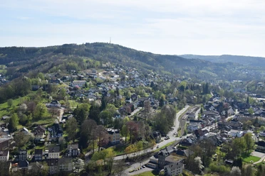 Blick vom Haldyturm Engelskirchen: Panoramablick auf grüne Hügel und dichte Wohnsiedlungen unter klarem Himmel.