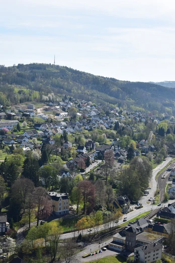 Blick vom Haldyturm Engelskirchen: Panoramablick auf grüne Hügel und dichte Wohnsiedlungen unter klarem Himmel.