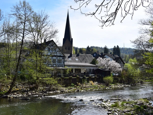 Agger in Ründeroth idyllisches Fachwerkdorf Engelskirchen an der Agger mit Kirche und blühenden Bäumen im Frühling.