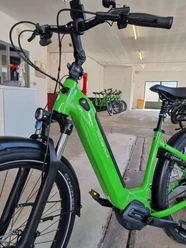 e-bike-verleih-bad-zwischenahn-nahaufnahme.jpg Ein leuchtend grünes E-Bike steht in einem hellen Raum mit weiteren Fahrrädern im Hintergrund.