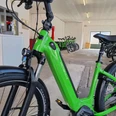 e-bike-verleih-bad-zwischenahn-nahaufnahme.jpg Ein leuchtend grünes E-Bike steht in einem hellen Raum mit weiteren Fahrrädern im Hintergrund.