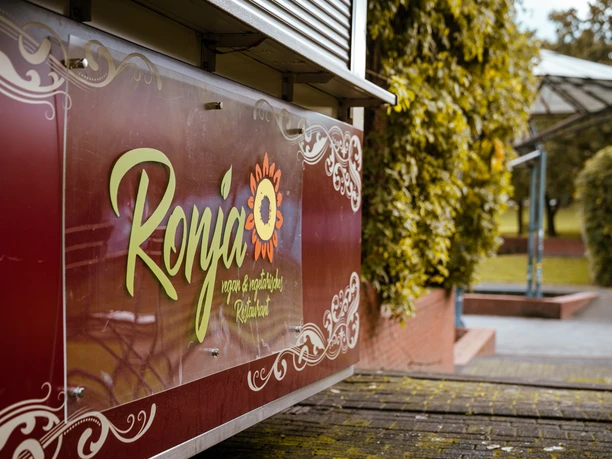 Ronjas im Ringlokschuppen, Mülheim a. d. Ruhr <p>Image eines Foodtrucks mit "Ropija" Logo in einem grünen Park bei bewölktem Wetter.</p>