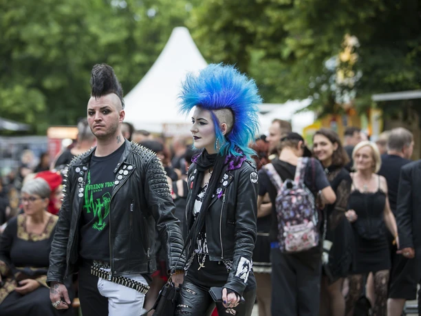 Gustavo.Hochman5.JPG Zwei Personen mit Irokesenschnitt und Lederjacken laufen durch eine Punk-Festival-Menge.