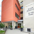IN VIA Hotel Moderne Hotelansicht mit orangefarbener Fassade und Eingangsbereich, umgeben von städtischer Umgebung.