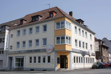 Südhotel Mehrstöckiges Hotelgebäude an einer Straßenecke, mit hellen Fassaden und markanten Fensterreihen.