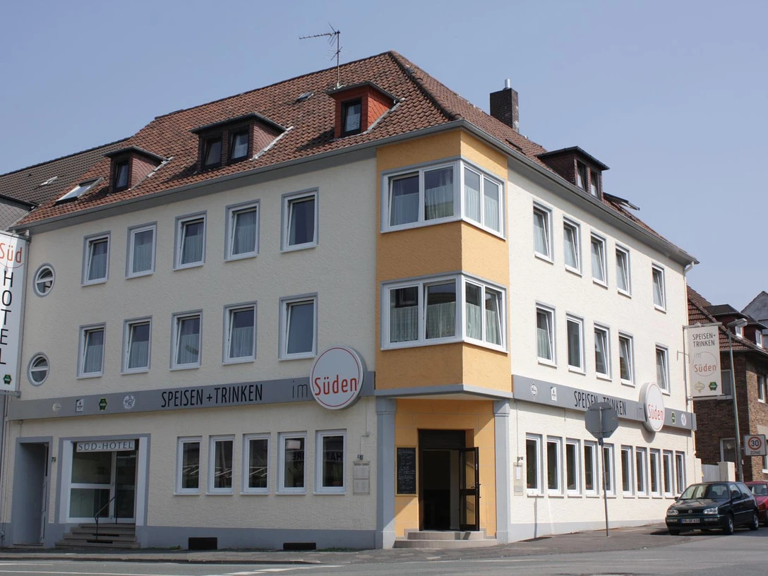 Südhotel Mehrstöckiges Hotelgebäude an einer Straßenecke, mit hellen Fassaden und markanten Fensterreihen.