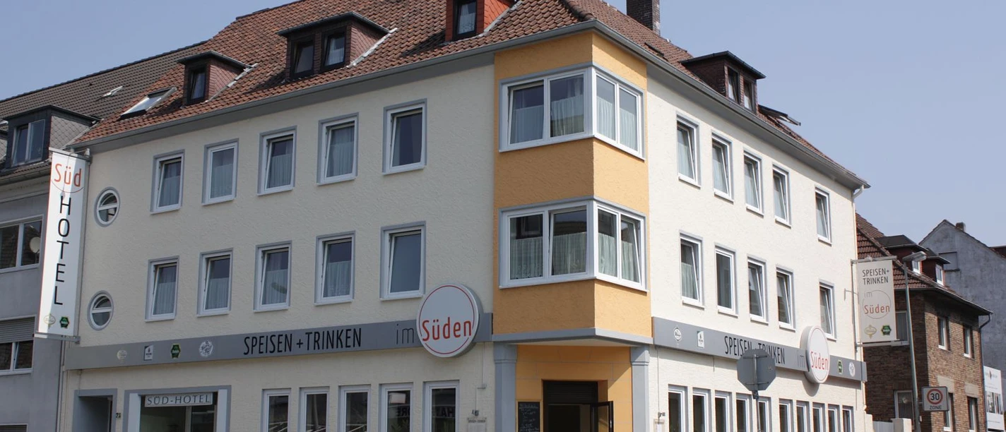 Südhotel Mehrstöckiges Hotelgebäude an einer Straßenecke, mit hellen Fassaden und markanten Fensterreihen.