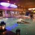 VitaSol Therme in Bad Salzuflen Ein beleuchtetes Innenpool der VitaSol Therme mit Gästen beim Schwimmen, umgeben von Kerzenlicht.
