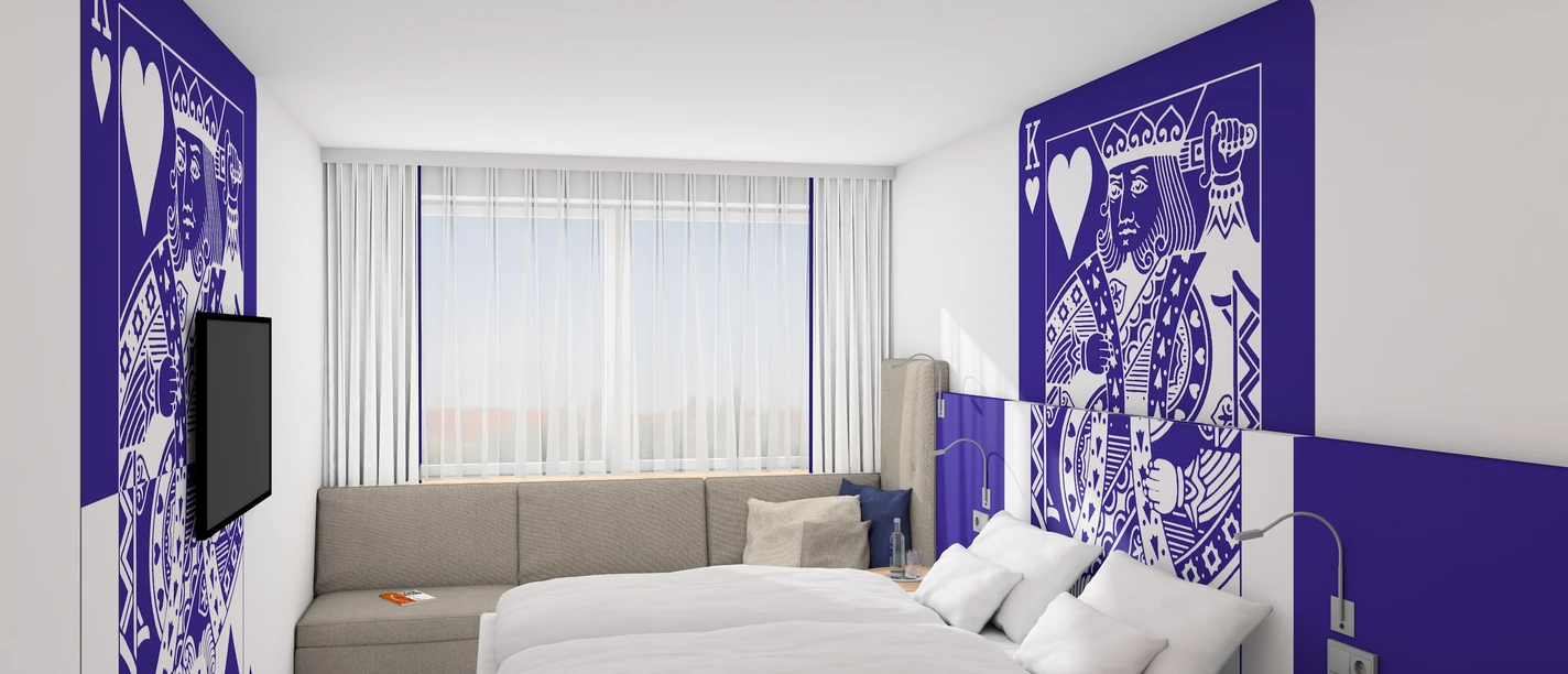 Moderne Hotelzimmer mit Doppelbett, stilvolle Kunst an Wänden, Sofa, Schreibtisch und großem Fenster.