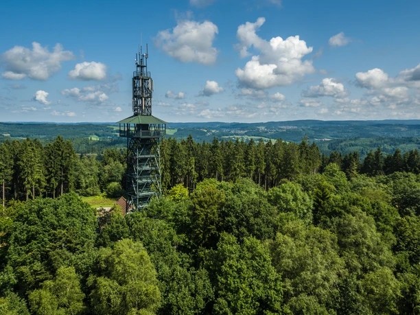 Das Bergische Ein Aussichtsturm erhebt sich über dichten Wald, umgeben von einer weiten, hügeligen Landschaft.