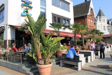 New Orleans.jpg Zu sehen ist der Außenbereich des New Orleans an einem belebten und sonnigen Tag. Auf der Terrasse gibt es viele Sitzgelegenheiten zwischen denen ebenfalls Palmen stehen, die ein gewisses Urlaubsgefühl vermitteln.